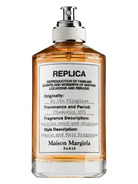 Maison Margiela Replica By the Fireplace Eau de Toilette bottle with orange liquid.